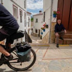 El alcalde de Benarrabá, Silvestre Barroso (d) observando el paso de un cicloturista un pueblo de unos 450 habitantes situado en el Valle del Genal