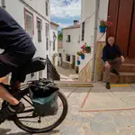 El alcalde de Benarrabá, Silvestre Barroso (d) observando el paso de un cicloturista un pueblo de unos 450 habitantes situado en el Valle del Genal