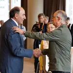 El presidente de Iberdrola, Ignacio Galán, y un accionista de la eléctrica se dan la mano