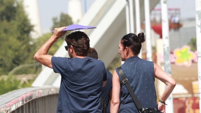 Dos personas se protegen del calor en Sevilla