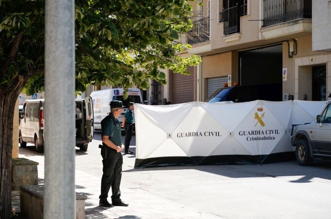 La Guardia Civil y los servicios funerarios en la puerta del domicilio donde se ha producido el asesinado de dos menores