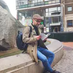 El escritor Roberto Ruiz Antúnez lee unos versos de &quot;Levitación y trance&quot; junto a la escultura de la Plaza España de Valladolid que rinde homenaje al voluntariado social