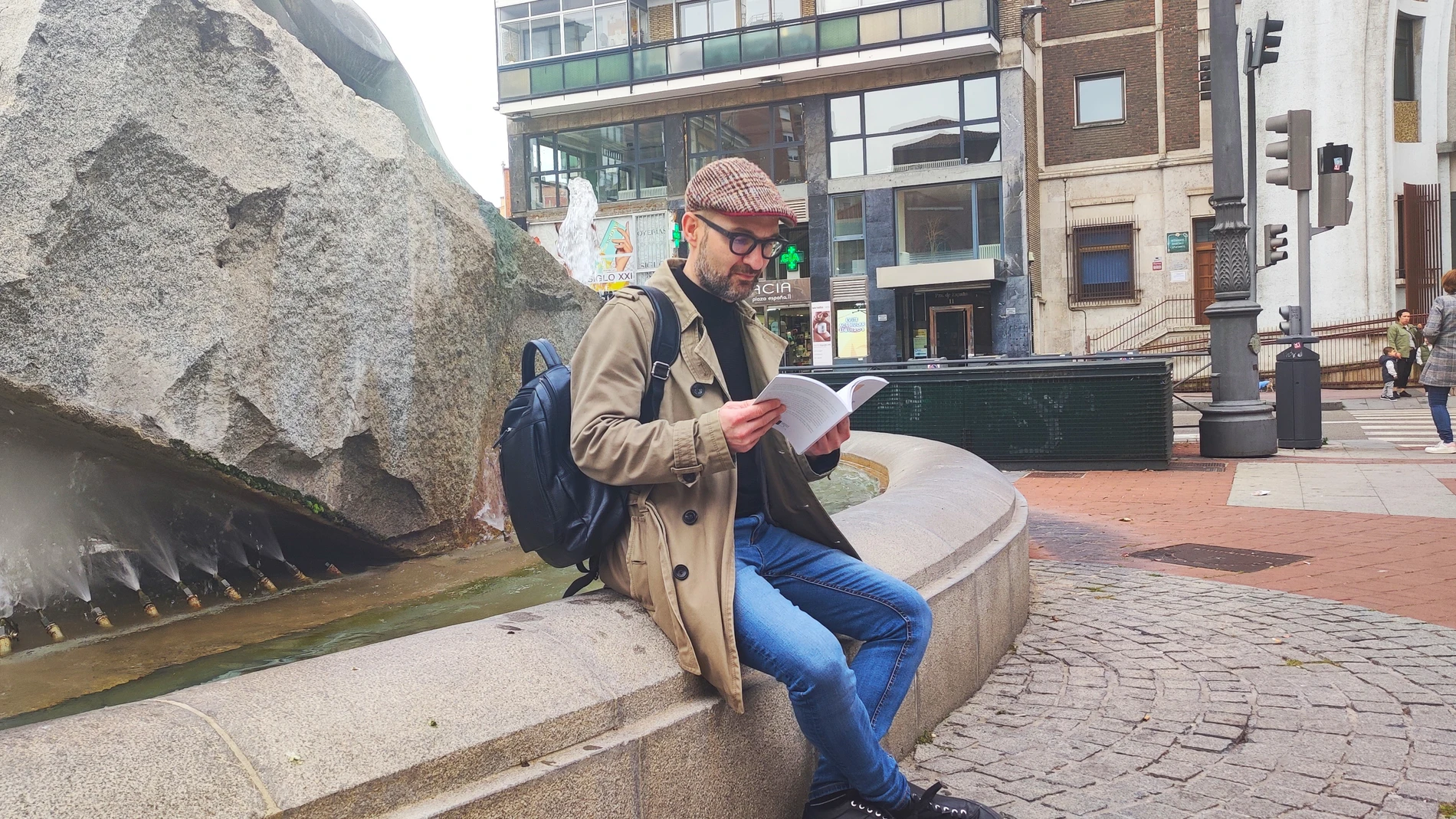 El escritor Roberto Ruiz Antúnez lee unos versos de "Levitación y trance" junto a la escultura de la Plaza España de Valladolid que rinde homenaje al voluntariado social