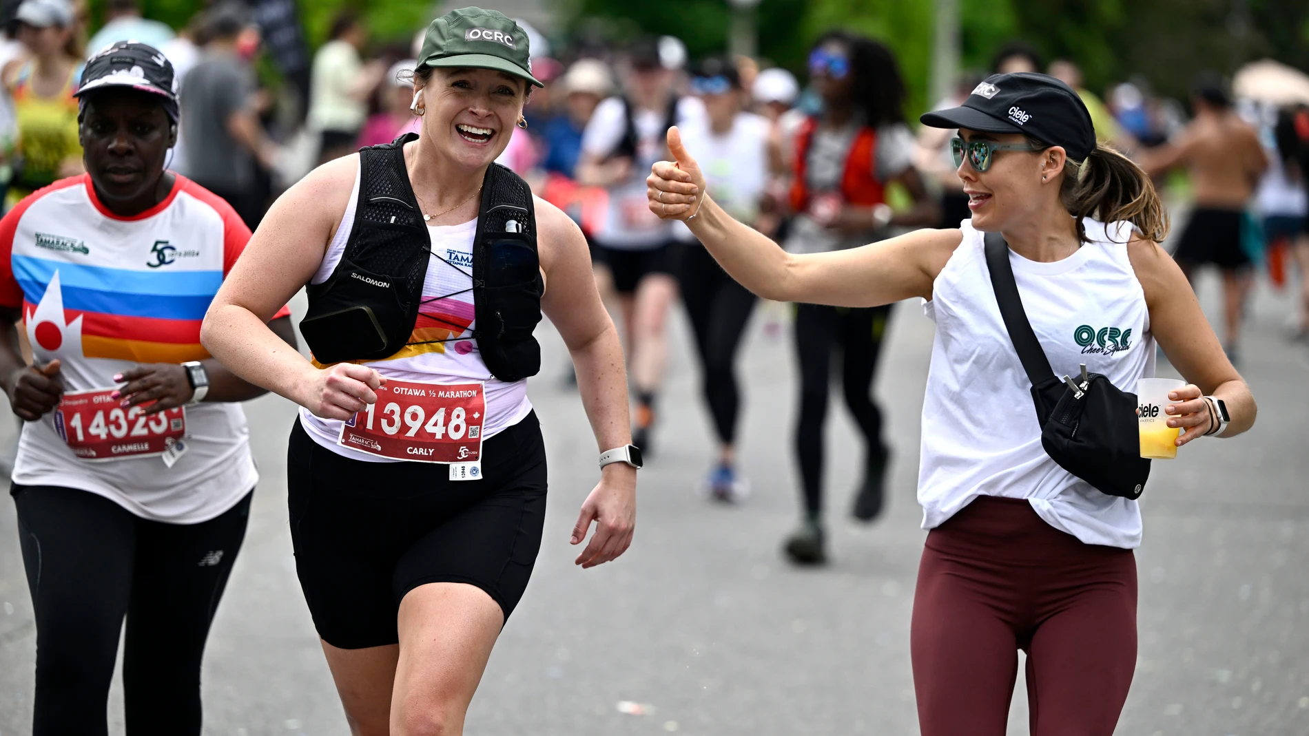 A runner is cheered on by a friend as they enter the final stretch of the half marathon of the Ottawa Race Weekend in Ottawa, Ontario, on Sunday, May 26, 2024. (Justin Tang/The Canadian Press via AP)