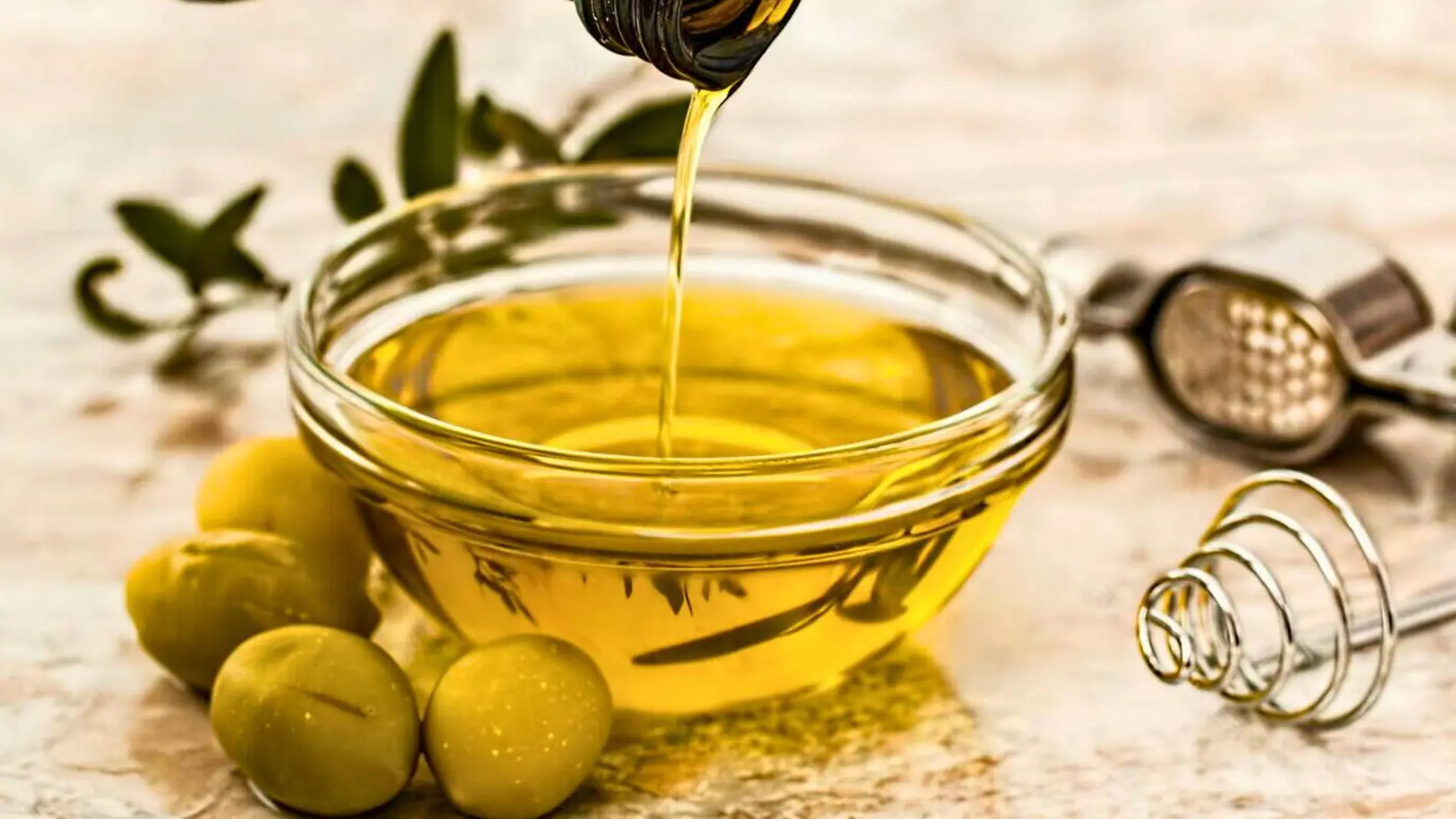 Un chorro de aceite de oliva con aceitunas beneficios para la salud el cerebro y alzheimer