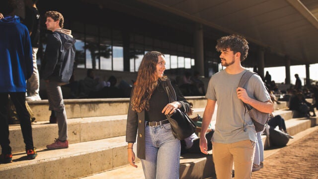 Dos jóvenes pasean por el Campus de Loyola