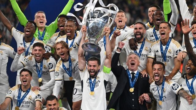 Real Madrid's Spanish defender #06 Nacho Fernandez (C) and Real Madrid's players lift the trophy to celebrate their victory at the end of the UEFA Champions League final football match between Borussia Dortmund and Real Madrid, at Wembley stadium, in London, on June 1, 2024.