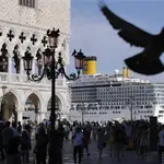 FILE - In this June 2, 2019 file photo, a cruise ship passes by St. Mark&#39;s Square filled with tourists, in Venice, Italy. Scientists say countries need to stop burning fossil fuels by 2050 at the latest to ensure global temperatures don&#39;t rise more than 1.5 degrees Celsius (2.7 Fahrenheit) this century. (AP Photo/Luca Bruno, File)