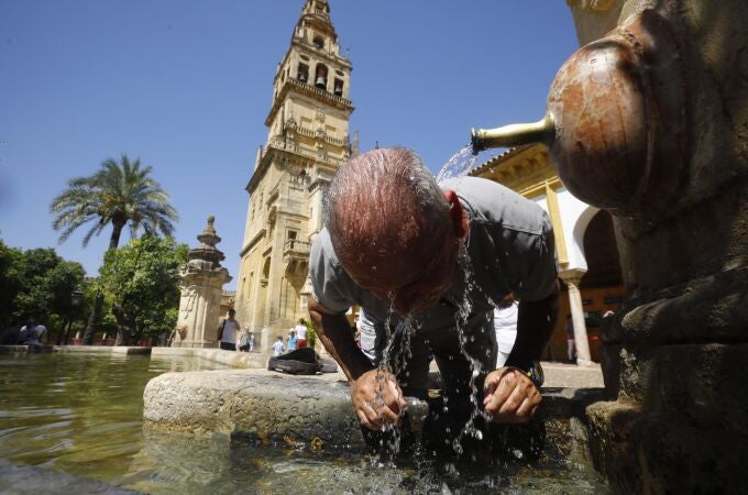 Un hombre se refresca en la fuente del patio de los naranjos de la Mezquita-Catedral de Córdoba. EFE/ Salas