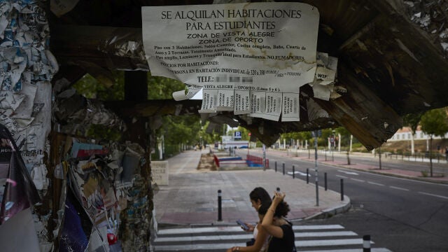 Carteles con ofertas de alquiler de habitaciones en Madrid.