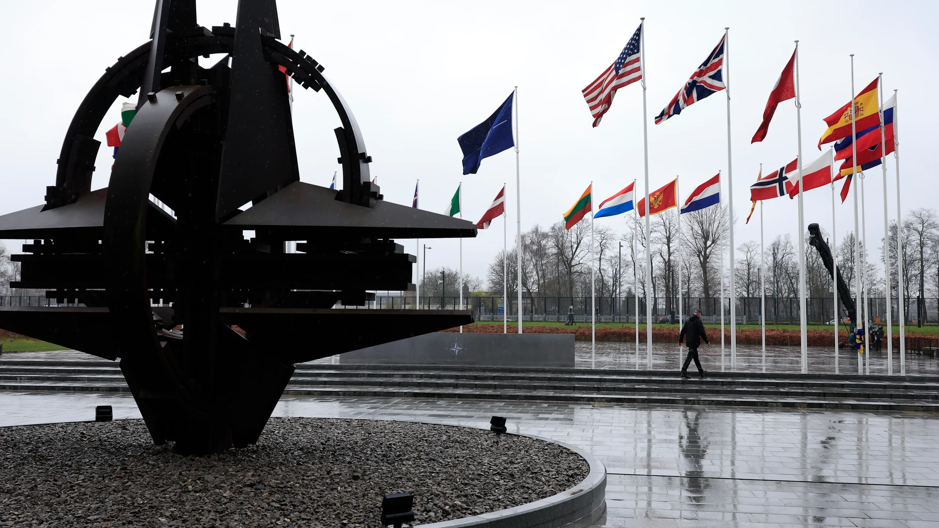 FILE - A man walks among flags of member countries as protocol prepare for a flag raising ceremony to mark the accession of Sweden at NATO headquarters in Brussels, Monday, March 11, 2024. U.S. President Joe Biden and his NATO counterparts are meeting in Washington this week to mark the 75th anniversary of the world's biggest security organization just as Russia presses its advantage on the battlefield in Ukraine. (AP Photo/Geert Vanden Wijngaert, File)
