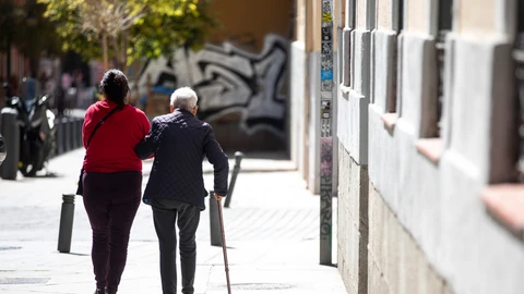 Imagen de una mujer mayor acompañada por su cuidadora.