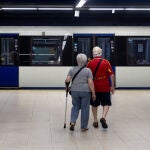 Una pareja de personas mayores se dispone a subir al metro