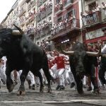  Mozos perseguidos por los toros de Victoriano del Río en el tercer encierro de los Sanfermines este martes, en Pamplona. 