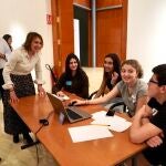 La consejera de Educación, Rocío Lucas, dialoga con un grupo de estudiantes que trabajan con un dispositivo digital