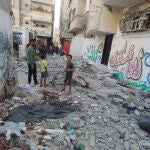 Palestinos observan los daños causados por un bombardeo israelí en el campo de refugiados de Nuseirat