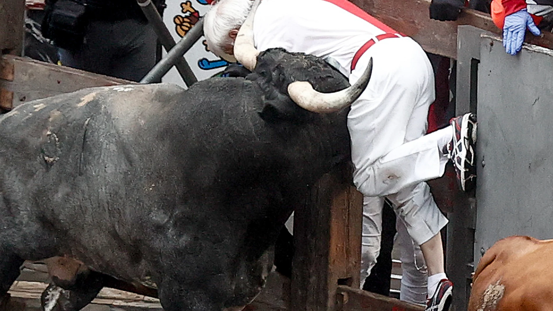 PAMPLONA, 14/07/2024.- Un mozo es embestido por uno de los toros de la ganadería sevillana de Miura durante el último encierro de los Sanfermines 2024, este domingo, en Pamplona. EFE/ Jesús Diges
