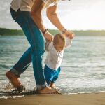 Primeros pasos de un niño en la playa
