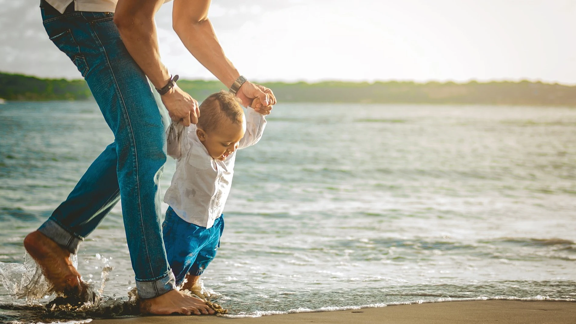 Primeros pasos de un niño en la playa