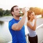 Dos jóvenes hidratándose después de hacer deporte