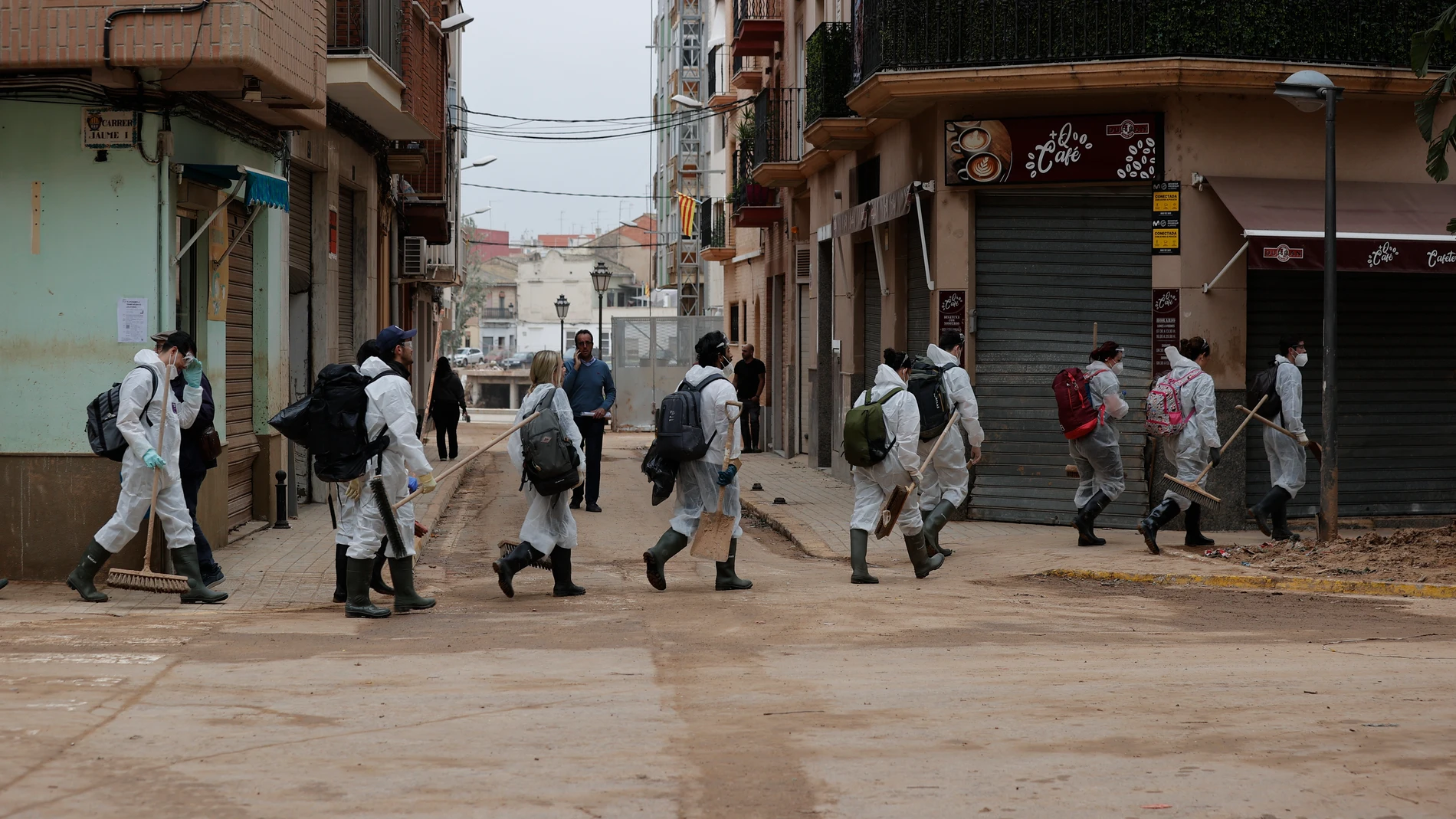 PAIPORTA (VALÈNCIA), 25/11/2024.- Voluntarios protegidos con epis y armados de cepillos se dirigen a continuar con las labores de limpieza del lodo en Paiporta, una de las localidades valencianas afectadas por la tragedia de la dana del pasado 29 de octubre. EFE/ Manuel Bruque