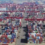 Containers are piled high at a port in Qingdao in eastern China's Shandong province Thursday, Nov. 8, 2018. Growth in Chinese exports to the United States ticked up in October as traders rushed to beat another round of tariff hikes. (Chinatopix via AP)