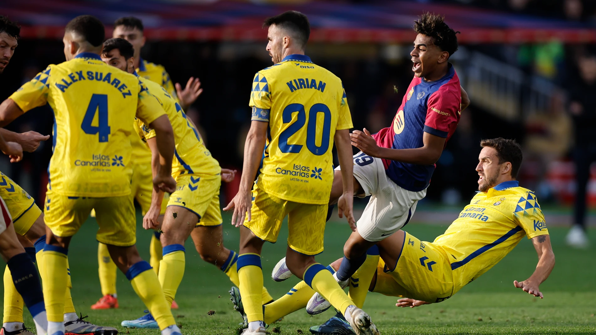 BARCELONA, 30/11/2024.- El delantero del FC Barcelona Lamine Yamal (2d) recibe una falta de Las Palmas durante su partido de LaLiga en el Estadio Olímpico Lluís Companys en Barcelona este sábado. EFE/Alberto Estévez