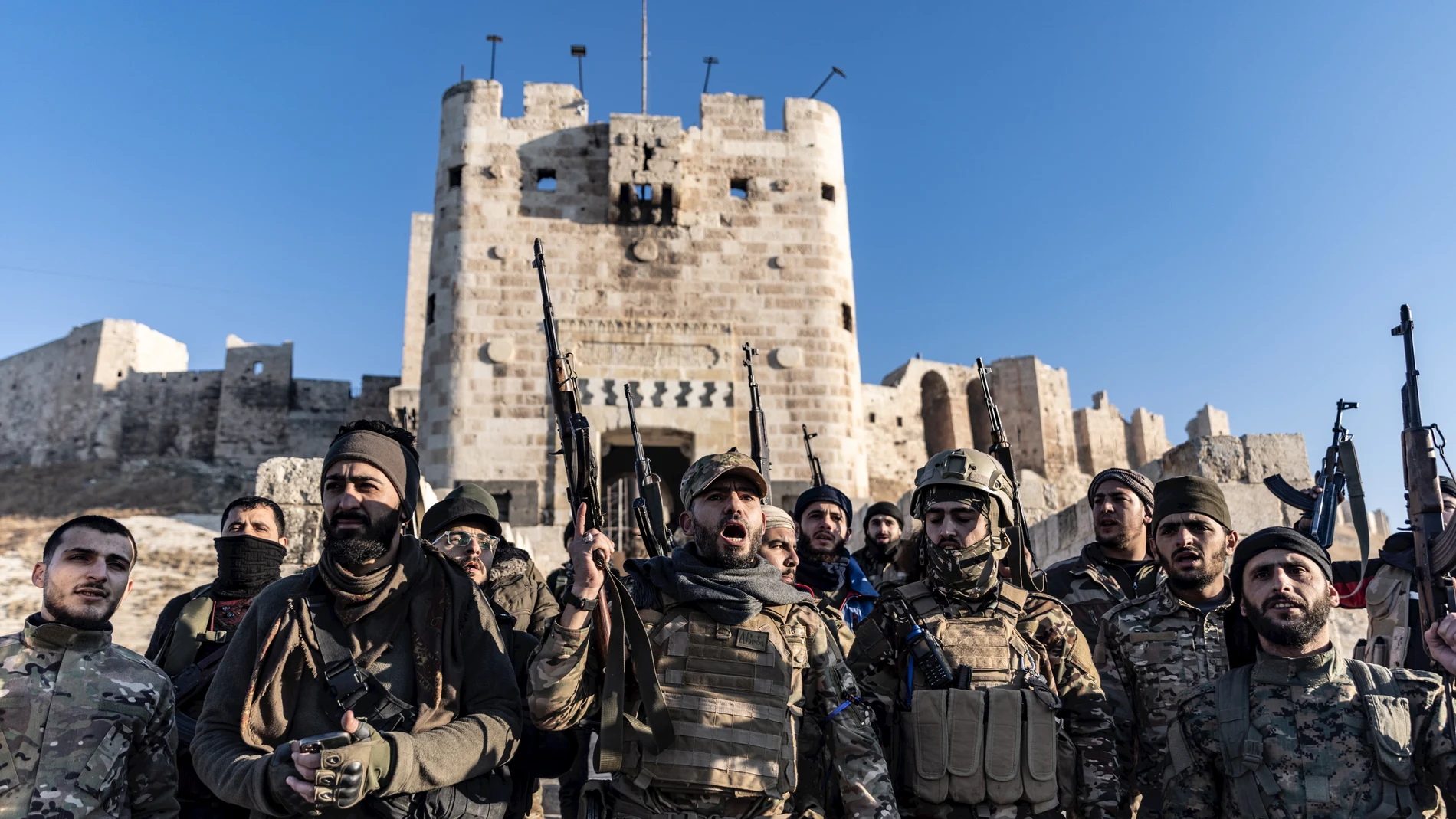 30 November 2024, Syria, Aleppo: Members of the Syrian armed opposition forces stand in front of the Ancient Castle of Aleppo after seizing control of most parts of Syria's second largest city.