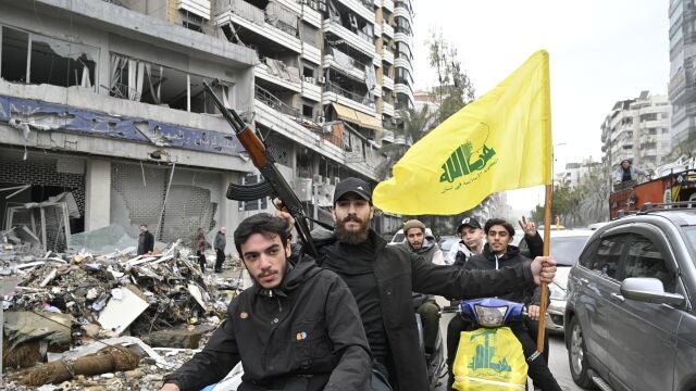 Lebanese people wave Hezbollah flags as they celebrate after a ceasefire with Israel came into effect, in the Dahieh district in southern Beirut, Lebanon, 27 November 2024