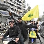 Lebanese people wave Hezbollah flags as they celebrate after a ceasefire with Israel came into effect, in the Dahieh district in southern Beirut, Lebanon, 27 November 2024