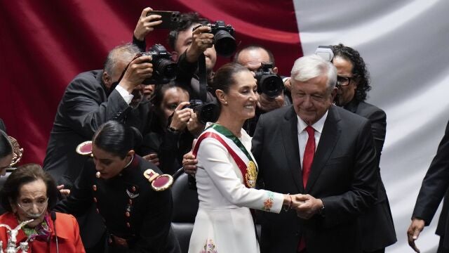 President Claudia Sheinbaum holds hands with outgoing President Andres Manuel López Obrador after taking the oath of office in the lower chamber of Congress, in Mexico City.