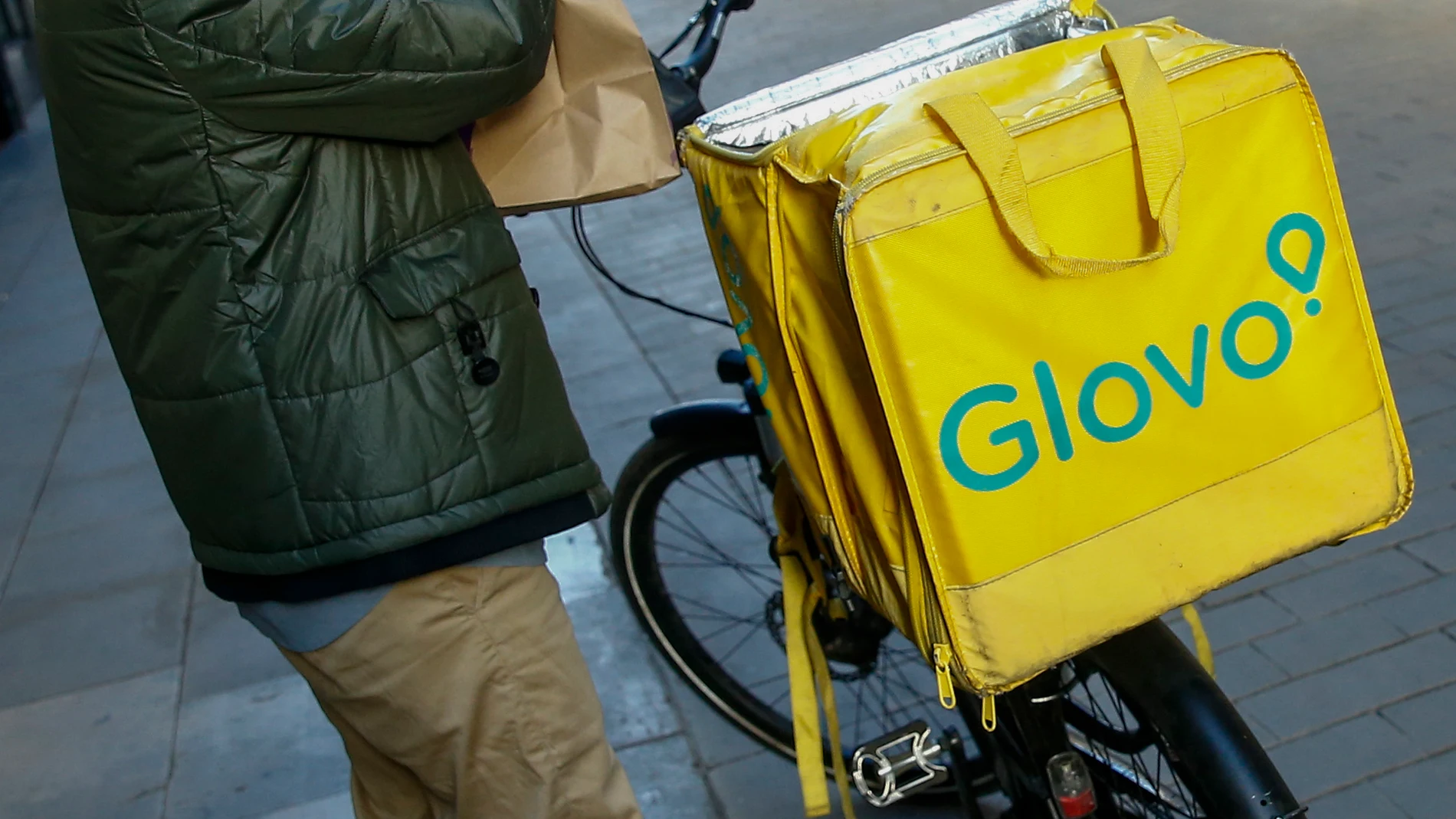 GRAFCAT1579. BARCELONA (ESPAÑA), 02/12/2024.- Un repartidor en una calle de Barcelona este lunes en que la plataforma de entregas a domicilio Glovo, ha anunciado que cambiará su modelo de relaciones con los trabajadores en España, basado hasta ahora en contar con repartidores autónomos, y realizará contratos laborales. EFE/ Quique García
