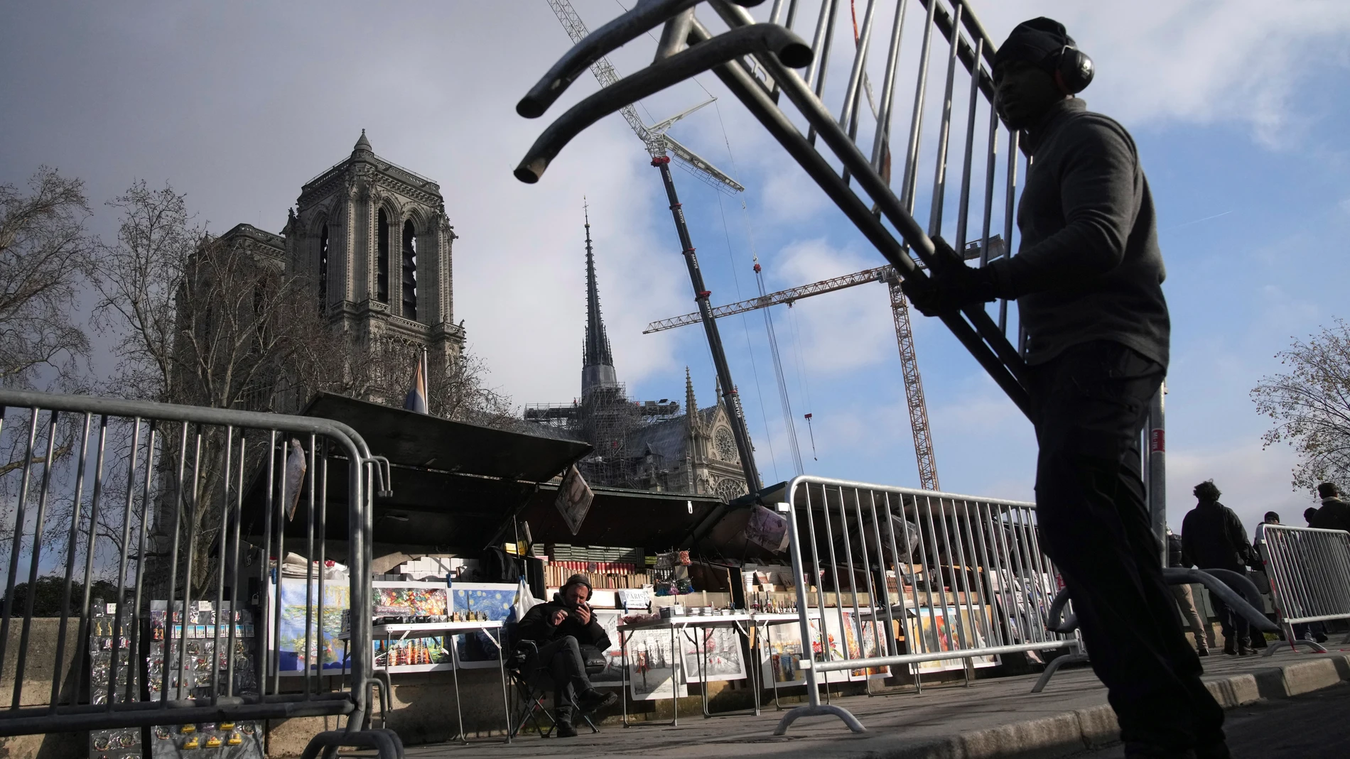 A worker installs barriers near Notre-Dame de Paris cathedral ahead of the Saturday's reopening of the Paris landmark monument and after more than five years of reconstruction following a devastating fire in 2019, Wednesday, Dec. 4, 2024 in Paris. (AP Photo/Christophe Ena)