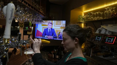 Una camarera sirve una cerveza en un bar de Versalles durante el discurso a la nación del presidente francés, Emmanuel Macron