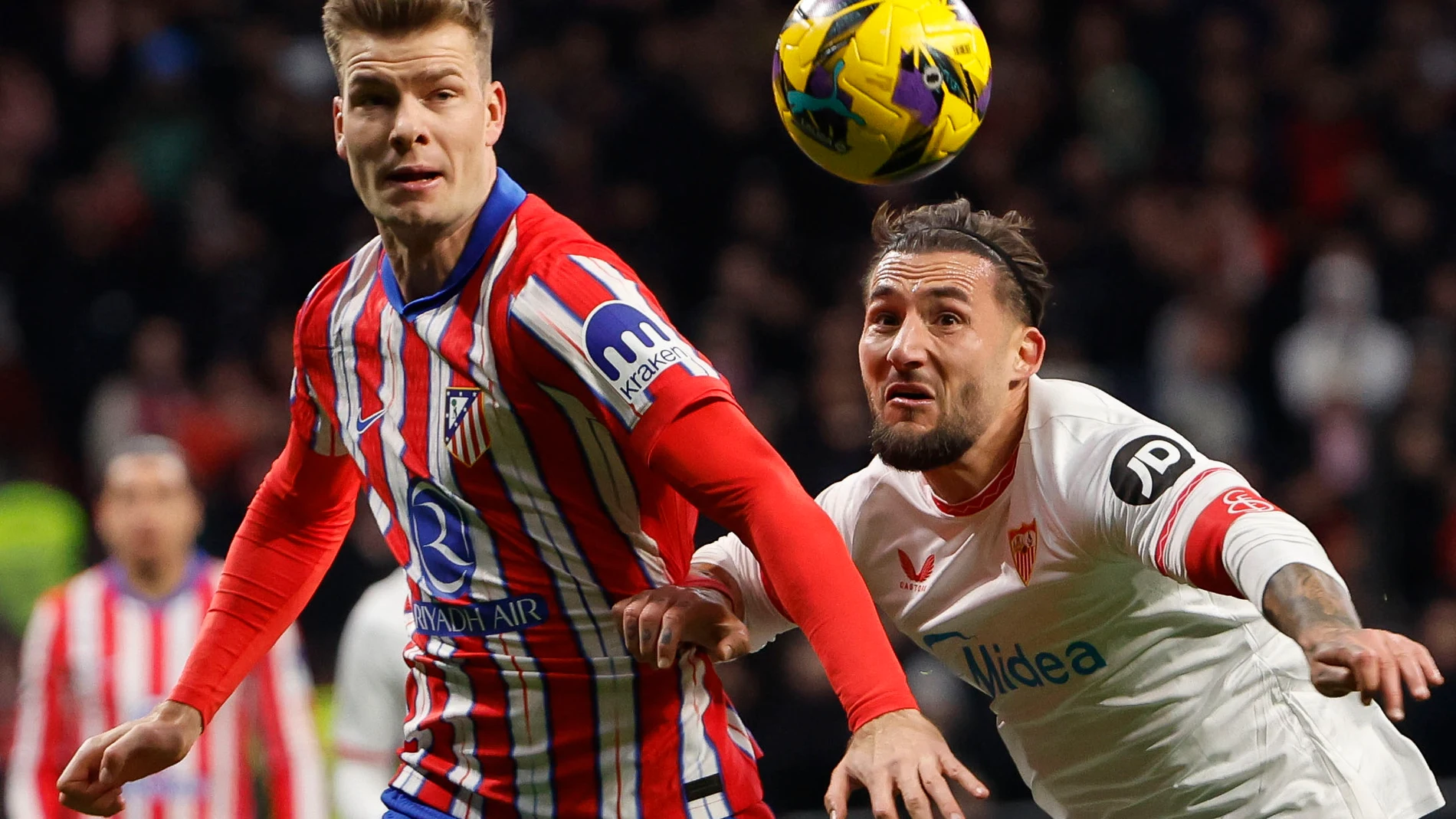MADRID, 08/12/2024.- El delantero noruego del Atlético de Madrid Alexander Sørloth disputa un balón ante el centrocampista serbio Nemanja Gudelj (d), durante el encuentro correspondiente a la jornada 16 de Laliga EA Sports que disputan hoy domingo Atlético de Madrid y Sevilla en el estadio Metropolitano, en Madrid. EFE / Sergio Perez.
