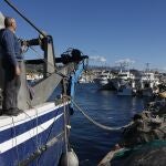 Un pescador observa los demás barcos de arrastre sin salir en el puerto de La Caleta de Vélez-Málaga (Málaga), este martes en el que los pescadores del Mediterráneo han amarrado sus barcos contra la propuesta de la Comisión Europea (CE), que recorta un 79 % los días en el mar, hasta las 27 jornadas al año, para los barcos arrastreros.