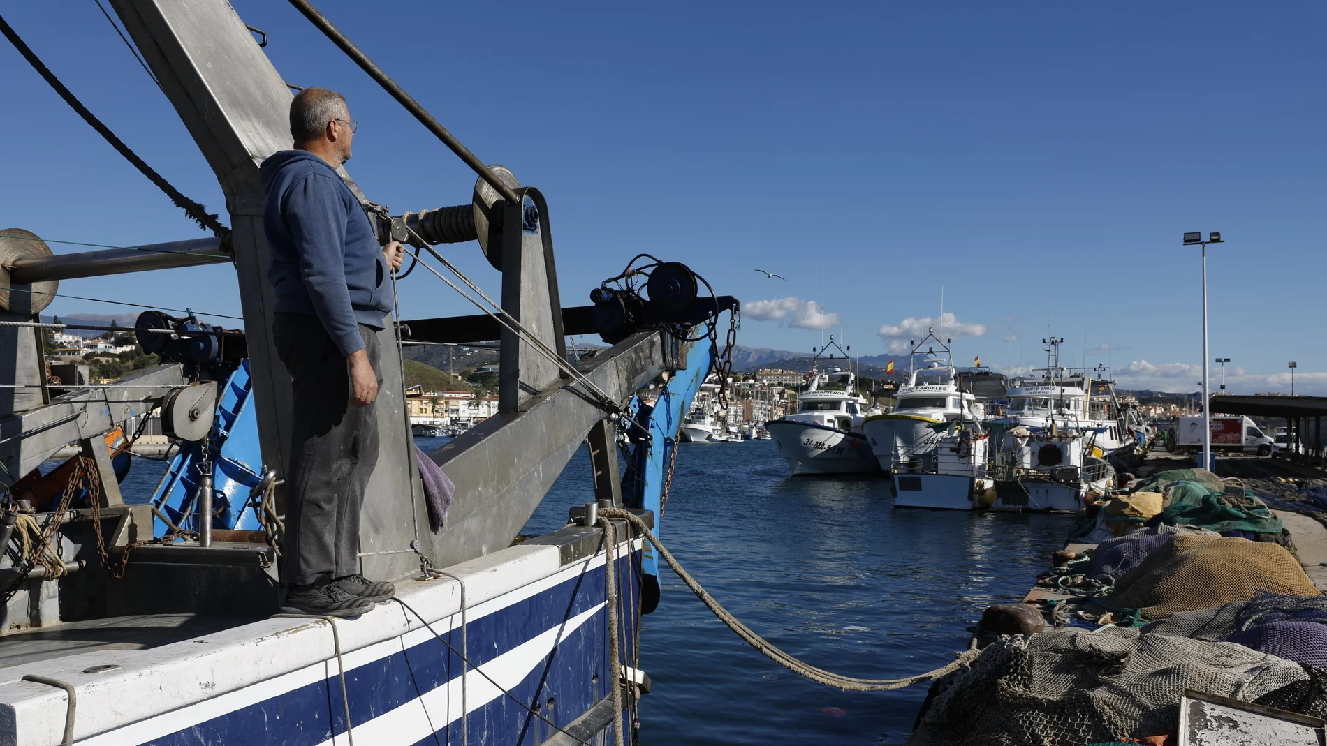 Un pescador observa los demás barcos de arrastre sin salir en el puerto de La Caleta de Vélez-Málaga (Málaga), este martes en el que los pescadores del Mediterráneo han amarrado sus barcos contra la propuesta de la Comisión Europea (CE), que recorta un 79 % los días en el mar, hasta las 27 jornadas al año, para los barcos arrastreros.