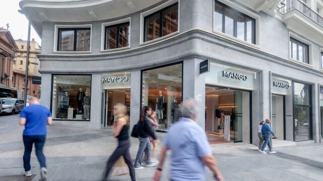 Varias personas pasan delante de la tienda de Mango, en Plaza de España,en Madrid.