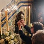 Una mujer invidente toca con sus manos el rostro de la réplica de la Virgen