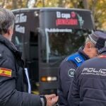 Agentes de la Policía Municipal, junto al presidente de Hazte Oír, Ignacio Arsuaga, y, de fondo, el autobús con el que piden la dimisión de Pedro Sánchez