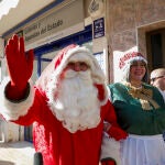 Una persona disfrazada de Papá Noel saluda ante la administración número 5 de Catarroja, en la zona cero de la dana del 29 de octubre, que ha vendido una serie del quinto premio, el 11.840