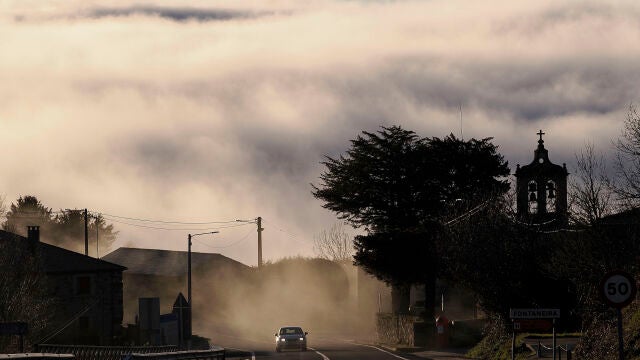 Un vehículo circula entre la niebla en la carretera LU-530 a su paso por A Fontaneira, Lugo