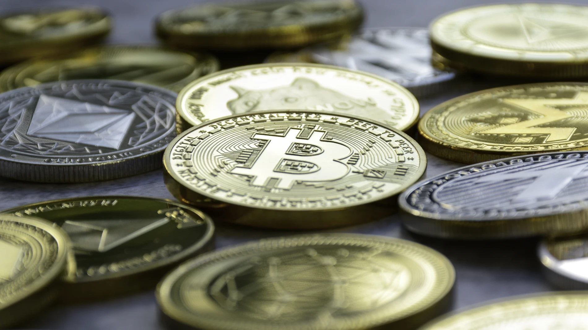 Pila de criptomonedas juntas. Bitcoin dorado en el medio.