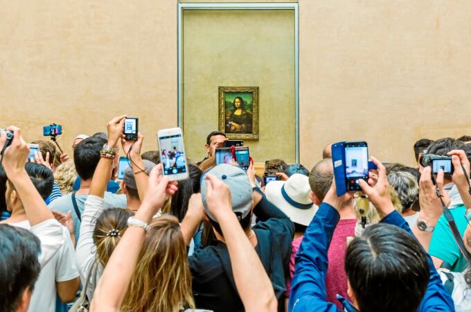 Visitantes toman la foto de Mona Lisa de Leonardo da Vinci en el museo del Louvre, en París