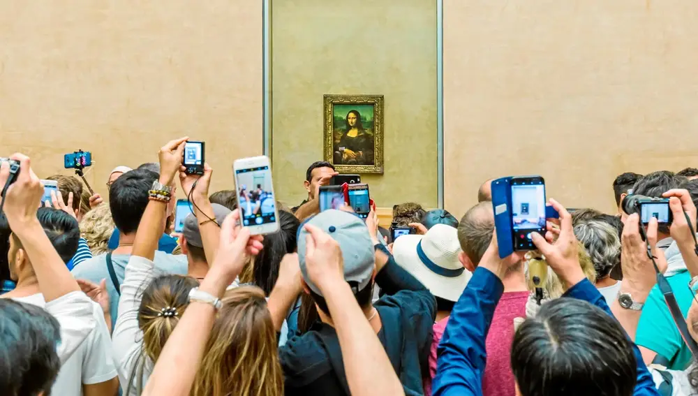Visitantes toman la foto de Mona Lisa de Leonardo da Vinci en el museo del Louvre, en París