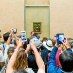 Visitantes toman la foto de Mona Lisa de Leonardo da Vinci en el museo del Louvre, en París