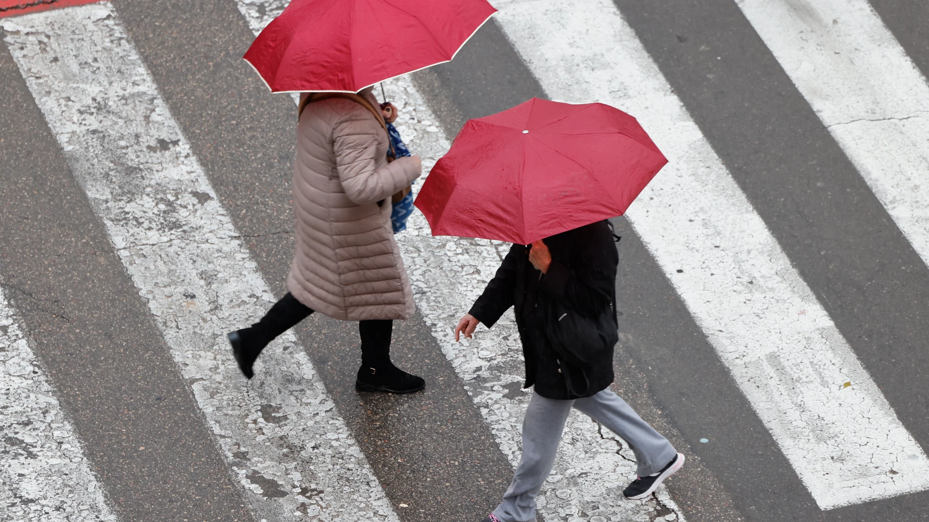 VALENCIA, 31/12/2024.- Varias personas se protegen de la lluvia este martes en Valencia. La Agencia Estatal de Meteorología (Aemet) ha establecido para este martes el aviso amarillo por una dana que dejará precipitaciones que pueden tener intensidad fuerte y ser persistentes en los litorales de Alicante y Valencia, con acumulados de 20 litros por metro cuadrado en una hora y hasta 60 litros en doce horas. EFE/Ana Escobar