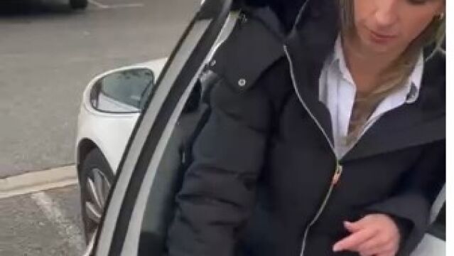 Lapersona sale del coche para comprobar lo que está en el suelo