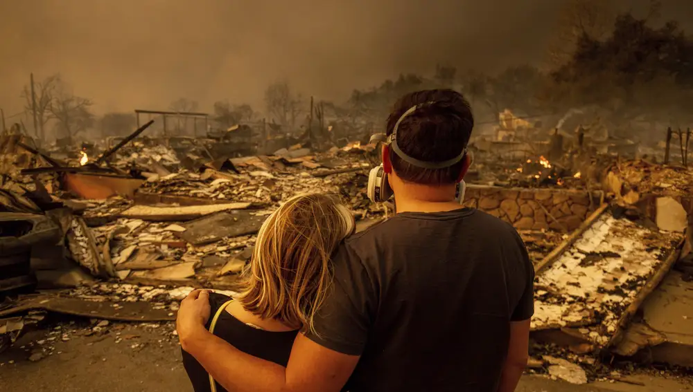 Megan Mantia, left, and her boyfriend Thomas, only first game given, return to Mantia's fire-damaged home after the Eaton Fire swept through the area, Wednesday, Jan. 8, 2025, in Altadena, Calif.
