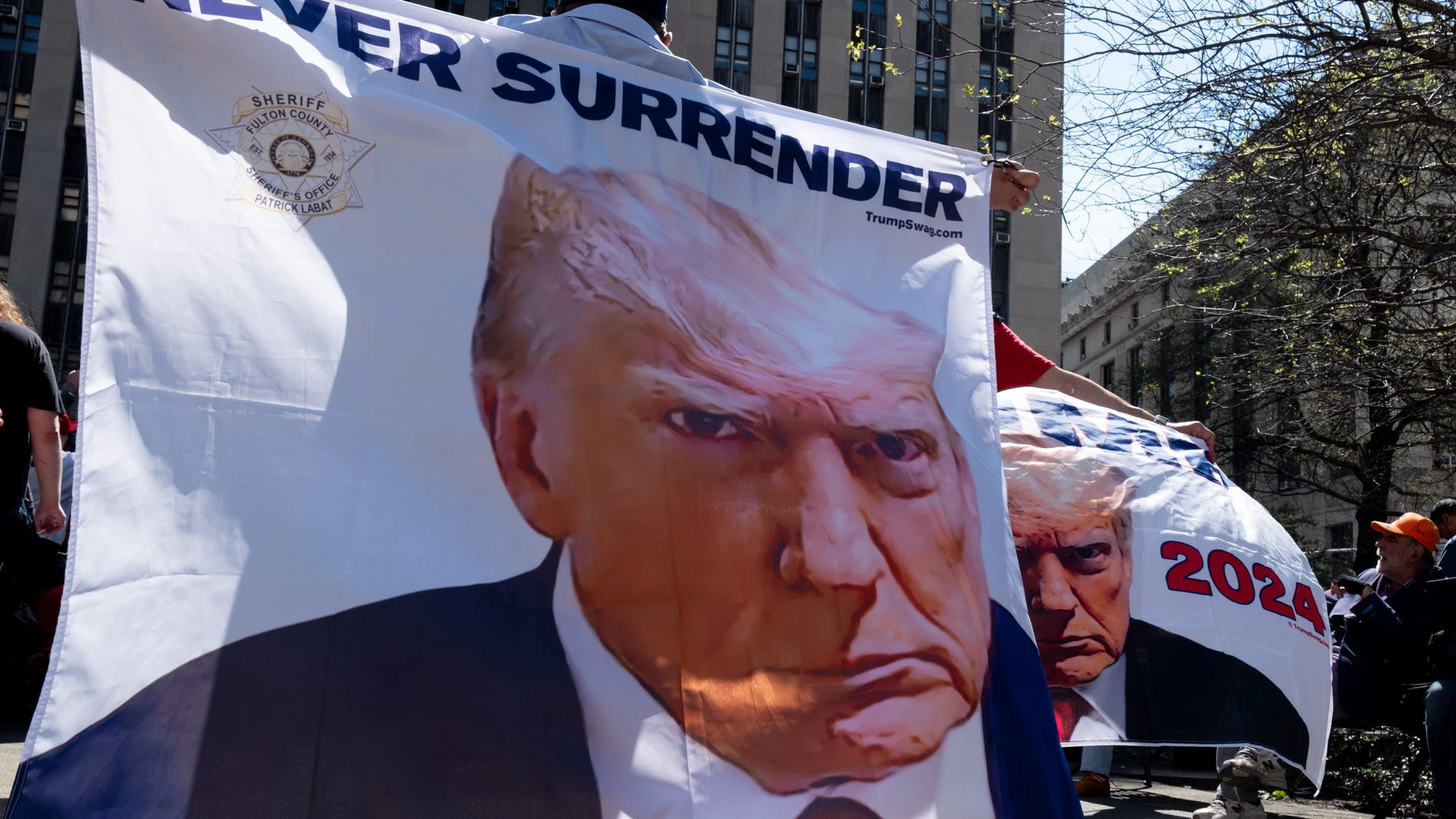 (Foto de ARCHIVO)April 15, 2024, New York, Ny, United States: Two men holding large Trump banners, one says ''Never Surrender'' the other says ''Trump 2024'' Trump supporters gathered across from the courthouse where jury selection begins for the trial of former President Donald Trump. Trump faces felony charges related to hush money paid to adult film actress Stormy Daniels. This is the first time in US history any former president will be tried on .criminal charges.Europa Press/Contacto...